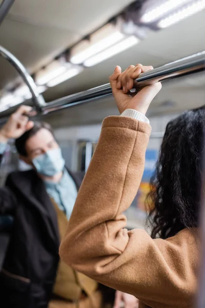 Afro-americana mulher de pé perto do homem no metrô no fundo borrado — Fotografia de Stock