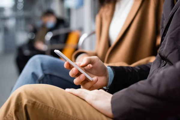 Vista ritagliata dell'uomo utilizzando lo smartphone in metropolitana — Foto stock