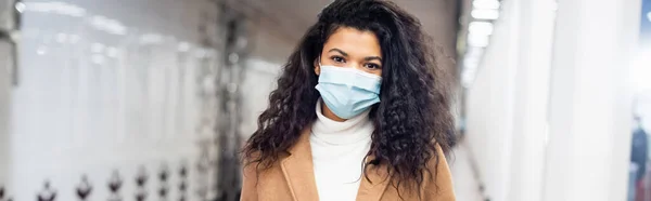 Femme afro-américaine bouclée en masque médical dans le métro, bannière — Photo de stock