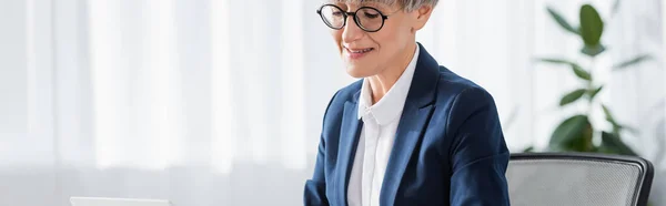 Happy team leader in glasses smiling in office, banner — Stock Photo