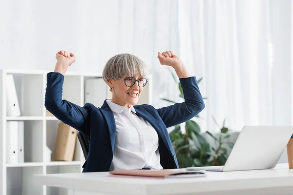 Happy team leader in glasses celebrating triumph in office — Stock Photo