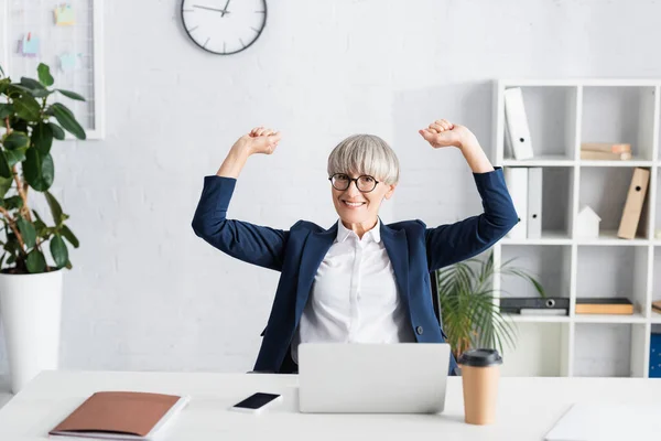 Líder de equipe alegre em óculos celebrando triunfo no escritório — Fotografia de Stock