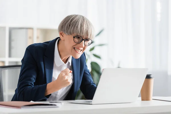Тривожний командний лідер в окулярах підбадьорює, дивлячись на ноутбук — стокове фото