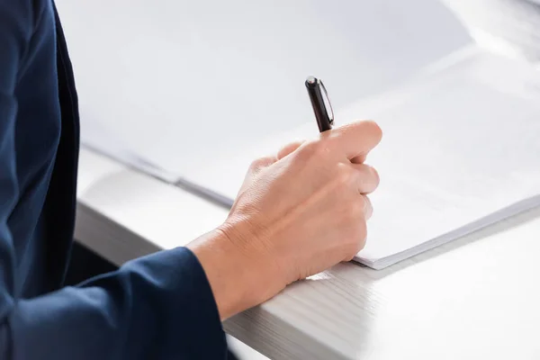 Cropped view of team leader signing document on desk — Stock Photo