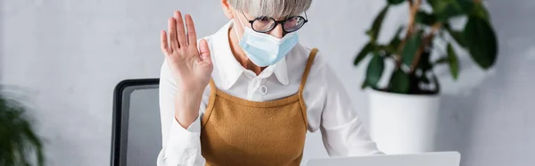 Leader del team di mezza età in occhiali e maschera medica che sventola mano, banner — Foto stock