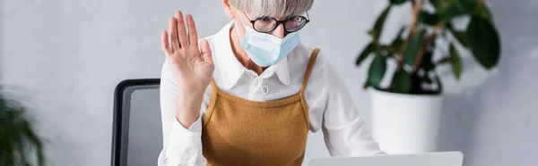 Leader del team di mezza età in occhiali e maschera medica che sventola mano, banner — Foto stock