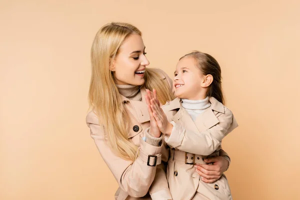 Alegre rubia madre y sonriente hija dando alta cinco aislado en beige - foto de stock