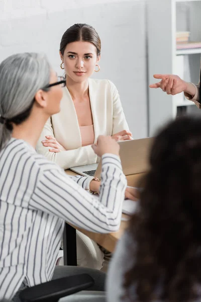 Teamleiter schaut asiatische Geschäftsfrau während eines Treffens im Büro an — Stockfoto