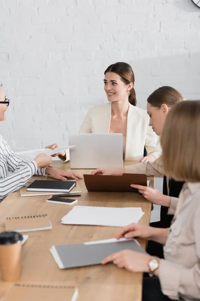 Asiático mujer de negocios dando documento a feliz equipo líder cerca compañeros de trabajo en oficina - foto de stock