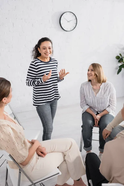 Oratore afroamericano sorridente in piedi vicino a un gruppo di donne durante il seminario — Foto stock