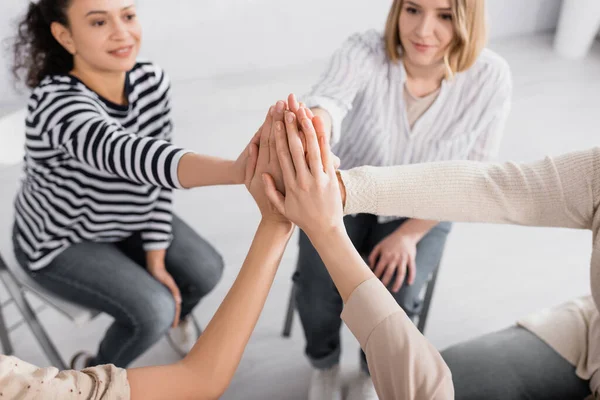 Grupo de mujeres multiculturales cogidas de la mano durante el seminario - foto de stock