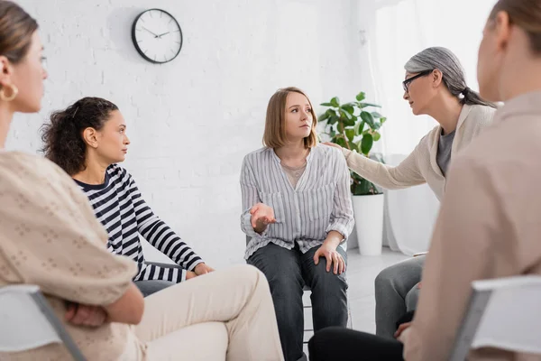 Asiatin unterstützt Mitarbeiterin bei Seminar im Besprechungsraum — Stockfoto