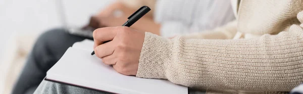 Partial view of businesswoman writing in notebook during seminar, banner — Stock Photo