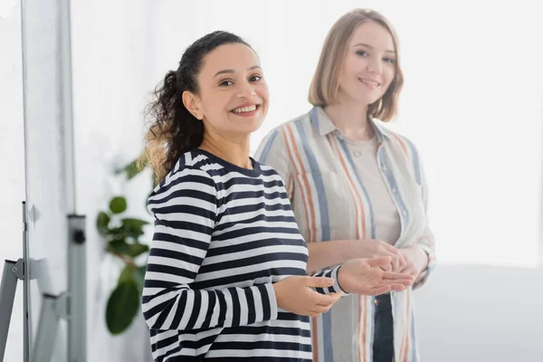 African american businesswoman smiling near colleague in meeting room — Stock Photo