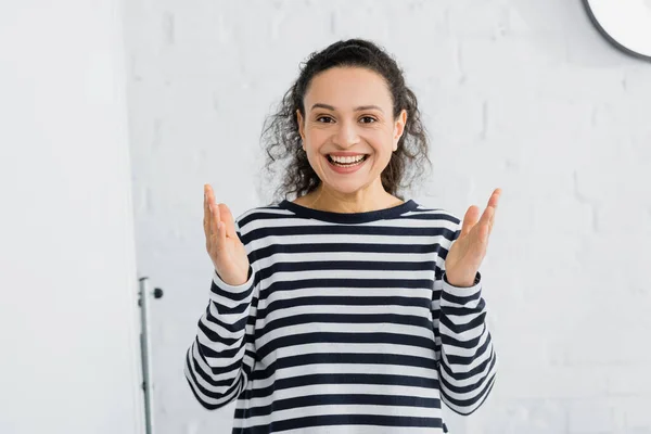 Cheerful african american speaker smiling near flipchart in meeting room — Stock Photo