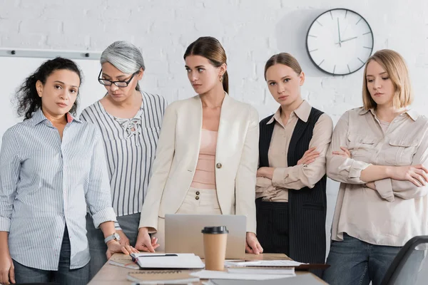 Multicultural businesswomen standing near desk in meeting room — Stock Photo