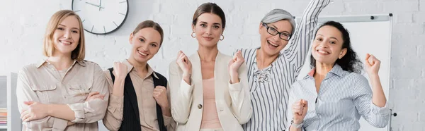 Excited multicultural businesswomen celebrating in meeting room, banner — Stock Photo