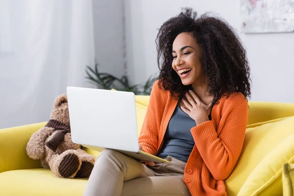 Joyful african american freelancer using laptop at home — Stock Photo