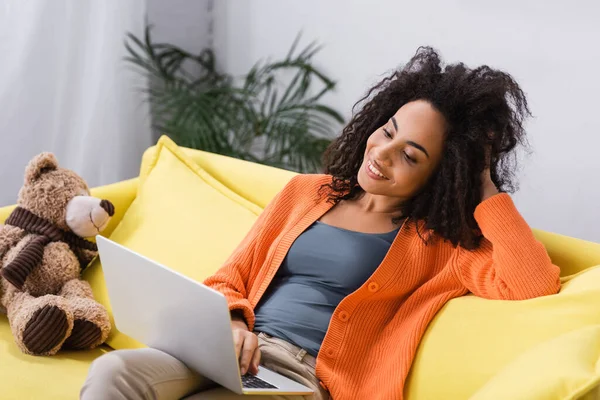 Freelancer afro-americano alegre olhando para laptop em casa — Fotografia de Stock