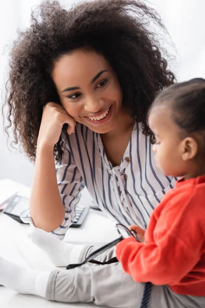 Afrikanisch-amerikanische Mutter blickt Tochter auf verschwommenem Vordergrund an — Stockfoto