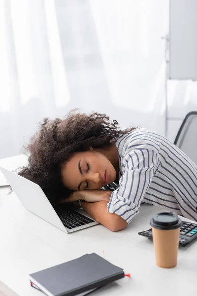 Tired african american woman sleeping on laptop at home — Stock Photo