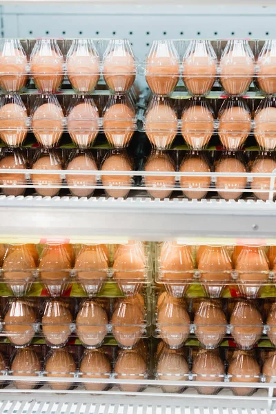 Huevos en bandejas de plástico en estantes en el supermercado - foto de stock