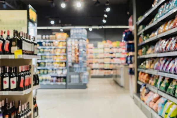 Unscharfer Hintergrund mit Flaschen und Lebensmitteln in Supermarktregalen — Stockfoto
