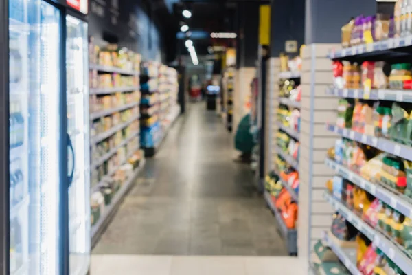 Blurred background with fridges and food in supermarket — Stock Photo