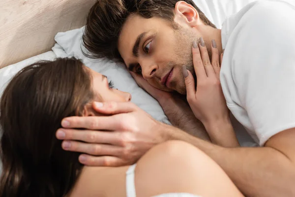 Top view of man and woman lying in bed and looking at each other — Stock Photo