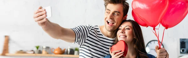 Feliz hombre y mujer tomando selfie en día de San Valentín, bandera - foto de stock