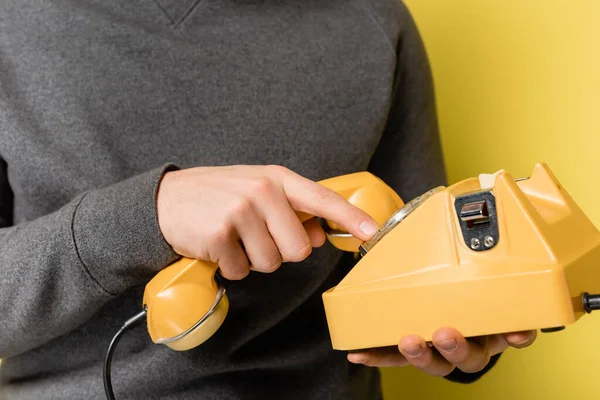Обрізаний вид людини, що використовує ретро телефон на жовтому тлі — стокове фото