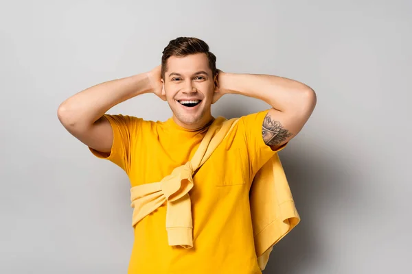 Веселий чоловік з руками біля голови на сірому фоні — Stock Photo