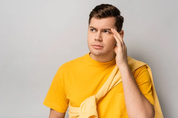 Uomo stressato guardando lontano su sfondo grigio — Foto stock