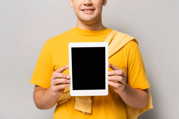 Cropped view of man holding digital tablet with blank screen on grey background — Stock Photo