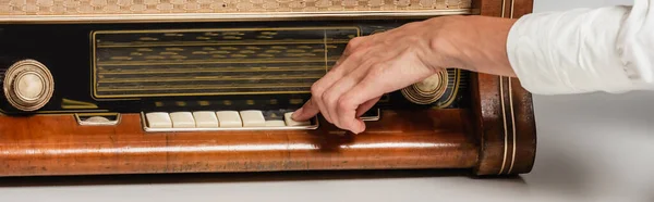 Cropped view of woman pressing buttons on vintage radio receiver, banner — Stock Photo