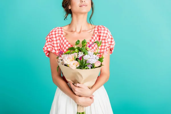 Partial view of woman in stylish retro clothes holding bouquet isolated on turquoise — Stock Photo
