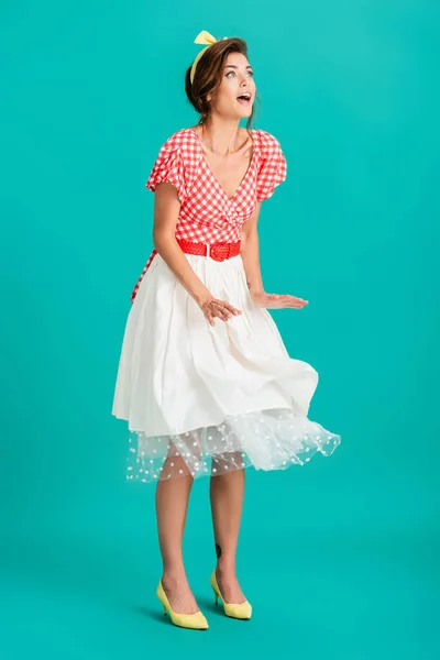 Amazed pin up woman looking away while standing on wind on turquoise — Stock Photo