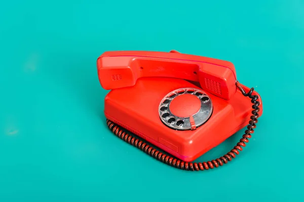 Telefono fisso rosso brillante vintage su sfondo turchese — Foto stock