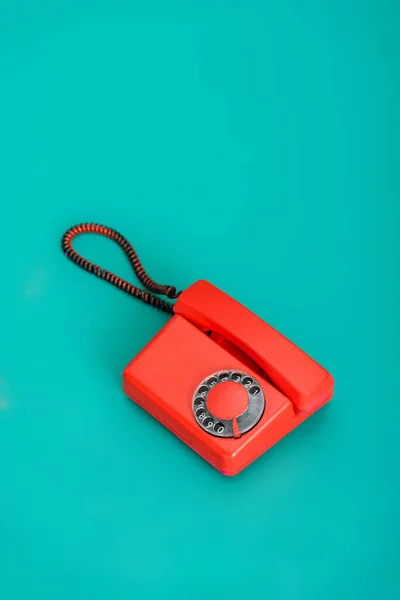 Vista de ángulo alto del teléfono vintage rojo brillante sobre fondo turquesa - foto de stock