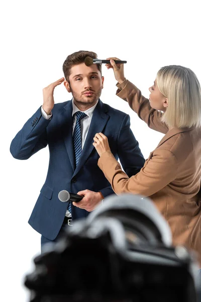 Maskenbildner pudert Gesicht des Nachrichtensprechers mit Kosmetikpinsel isoliert auf weißem, verschwommenem Vordergrund — Stockfoto