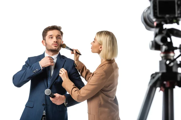 Broadcaster adjusting tie while makeup artist powdering his face isolated on white, blurred foreground — Stock Photo