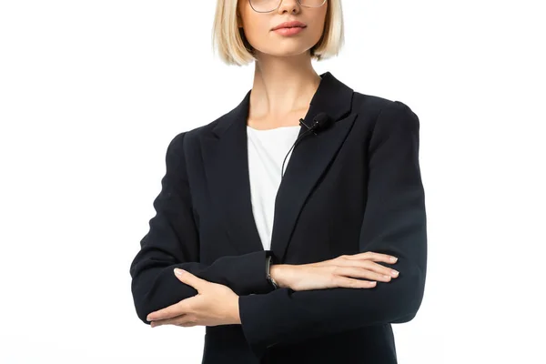 Vista parcial de la presentadora en blazer negro de pie con brazos cruzados aislados en blanco - foto de stock