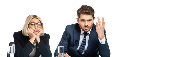Discouraged broadcaster gesturing near upset colleague isolated on white, banner — Stock Photo
