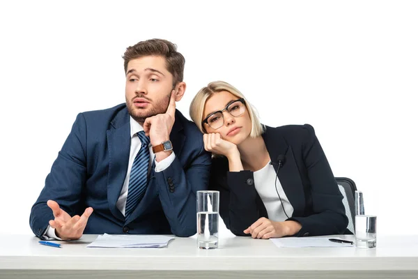 Cansada rubia presentadora de noticias apoyada en aburrido colega en el lugar de trabajo aislado en blanco - foto de stock