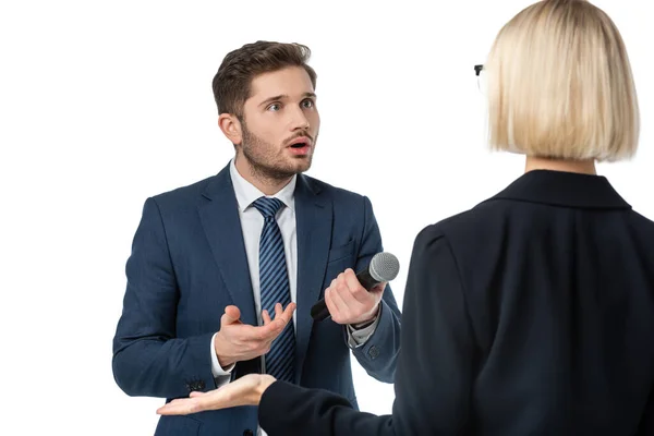 Rückansicht der blonden Geschäftsfrau in der Nähe erstaunt Interviewer mit Mikrofon isoliert auf weiß — Stockfoto