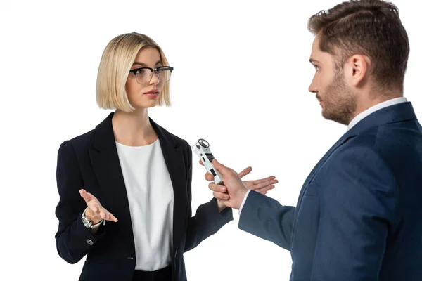 Blonde businesswoman showing shrug gesture while giving interview to journalist isolated on white — Stock Photo