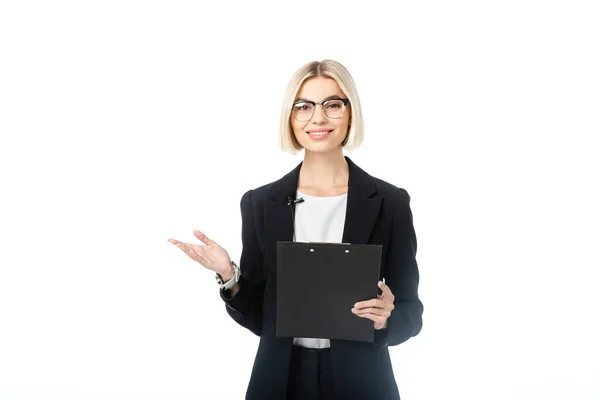 Lächelnder Sender, der mit der Hand zeigt, während er Klemmbrett isoliert auf weiß hält — Stockfoto