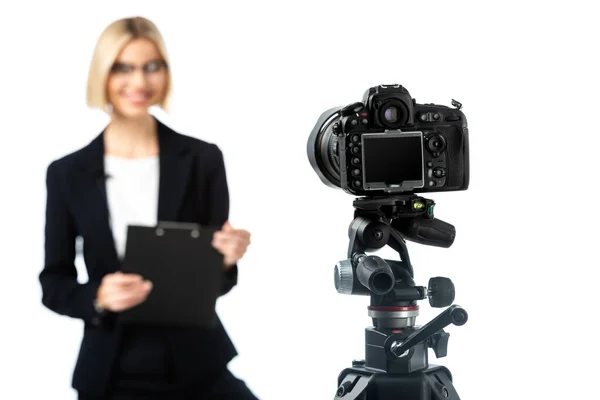 Selective focus of digital camera near news anchor with clipboard on blurred background isolated on white — Stock Photo