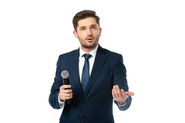 Amazed anchorman with microphone pointing with hand while looking at camera isolated on white — Stock Photo