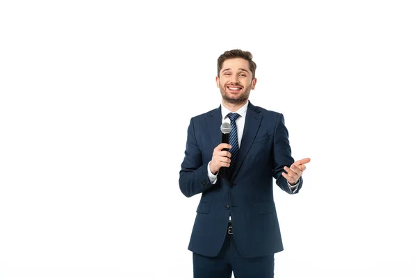 Junger, fröhlicher Nachrichtenkommentator mit Mikrofon, das mit weißer Hand zeigt — Stockfoto